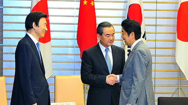 日本首相安倍晉三8月24日集體會見在東京出席第八次中日韓三國外長會的中國外長王毅、日本外相岸田文雄和韓國外長尹炳世。圖為安倍（右）落座前與王毅（中）、尹炳世（左）寒暄。中新社記者 王健 攝