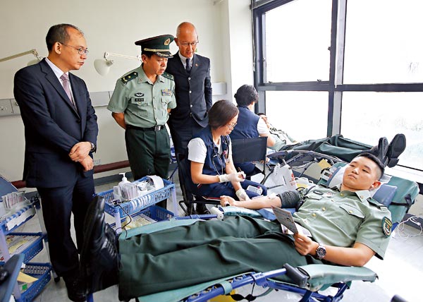 解放軍駐港部隊昨舉行無償獻血活動，解放軍駐港部隊副司令員廖正榮（左二）仔細了解獻血程序