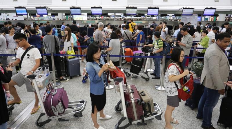 　　圖：「妮妲」中午遠離本港，航空公司陸續恢復辦理登機手續，不少登機櫃位迫滿旅客大公報記者何嘉駿攝