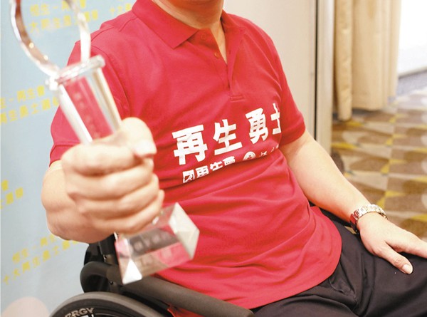 伍強在輪椅上堅持服務警隊逾卅年，退休後每日做義工，獲頒「十大再生勇士」。 劉國權 攝