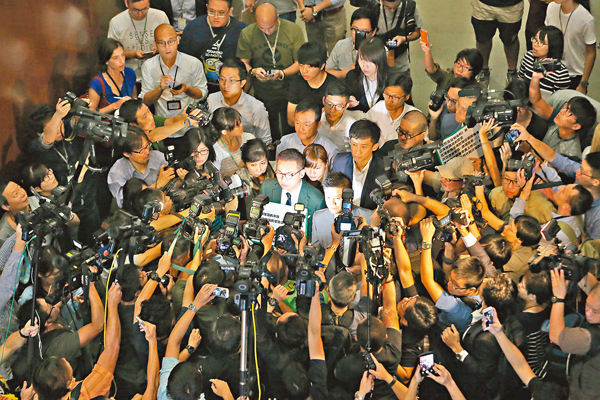 昨日游蕙禎、梁頌恆在反對派築起「人墻」保護下，強行闖入立法會會議廳。 莫雪芝 攝