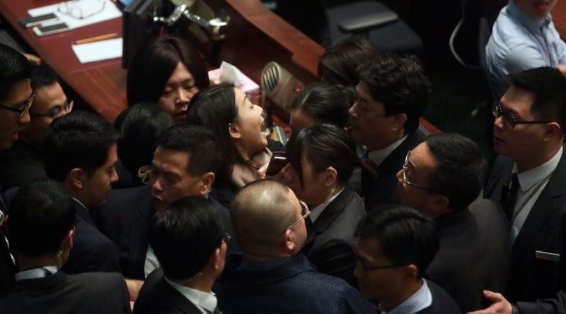 女保安員將劉小麗帶離議事廳時，被多名反對派議員圍堵阻止，場面相當混亂/大公報記者