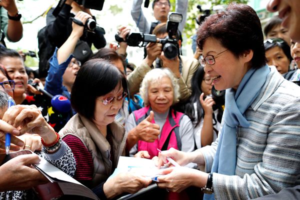 Chief Executive election candidate and former Chief Secretary Carrie Lam signs autographs for supporters during an election campaign in Hong Kong, China March 23, 2017. REUTERS/Tyrone Siu