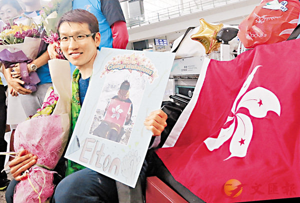 成功登上珠峰的港人吳俊霆昨日返港，抵達機場時獲親友贈送鮮花祝賀。 香港文匯報記者彭子文 攝