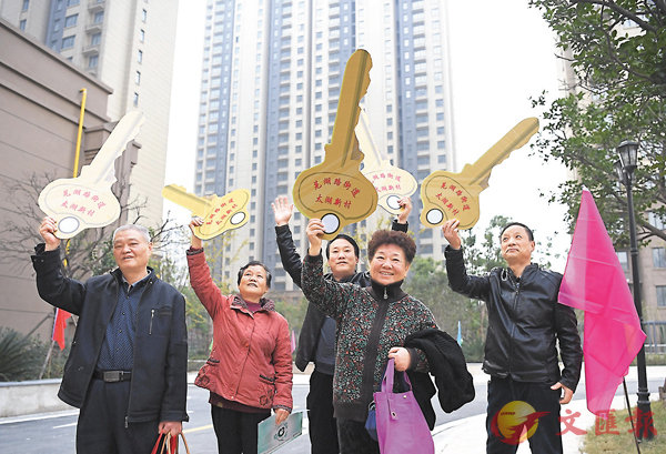 此次政治局會議提出明年將加快住房制度改革和長效機制建設。圖為近日安徽合肥老舊小區升級後，分得新居的回遷住戶舉起鎖匙模型慶祝。資料圖片