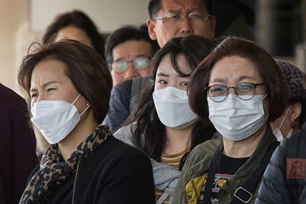 Passengers wear face masks to protect against the spread of the Coronavirus as they arrive on a flight from Asia at Los Angeles International Airport, California, on January 29, 2020. - A new virus that has killed more than one hundred people, infected thousands and has already reached the US could mutate and spread, China warned, as authorities urged people to steer clear of Wuhan, the city at the heart of the outbreak. (Photo by Mark RALSTON / AFP) (Photo by MARK RALSTON/AFP via Getty Images)