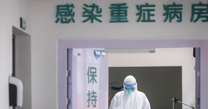 In this photo released by China's Xinhua News Agency, a medical staff member wearing protective a suit works in the department of infectious diseases at Wuhan Union Hospital in Wuhan in central China's Hubei Province, Tuesday, Jan. 28, 2020. Hong Kong's leader announced Tuesday that all rail links to mainland China will be cut starting Friday as fears grow about the spread of a new virus. (Xiao Yijiu/Xinhua via AP)